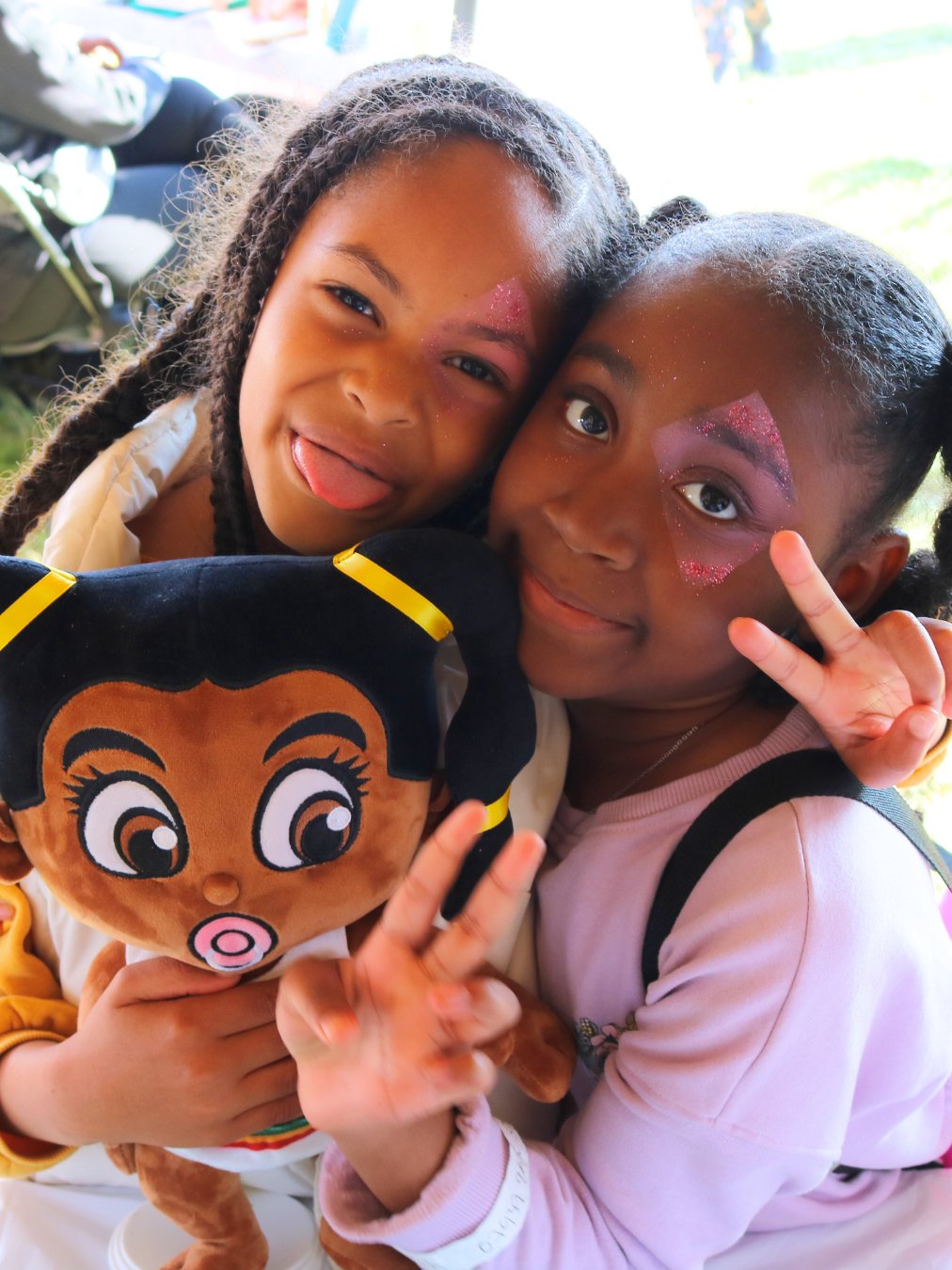 Five Nine Mile Babies plush dolls with different shades of melanin skin tones and afro hairstyles are arranged together, all wearing white outfits. The black plush toy dolls have large, expressive eyes and cheerful expressions, sitting on a blanket.